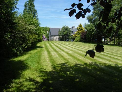 a large grassy yard with a house in the background at Emerald Coast Gites and Lodge in Hénansal