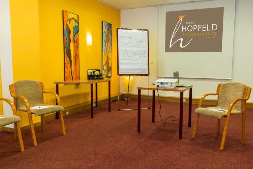 a room with two tables and chairs and a whiteboard at Familie Hopfeld - Hotel Dreikönigshof in Stockerau