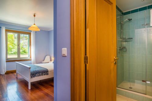 a bedroom with a bed and a shower and a bathroom at The Cliff Side Apartment in Funchal