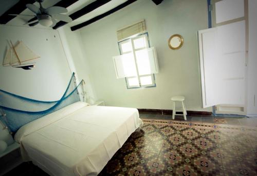 a bedroom with a bed and a window and a clock at The Old Fisherman´s House in Villajoyosa
