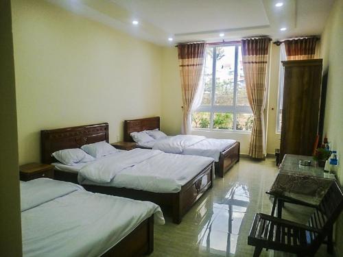 sypialnia z 3 łóżkami i oknem w obiekcie ATP Guesthouse w mieście Da Lat