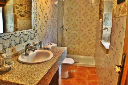 a bathroom with a sink and a toilet at Casa Combarro in Combarro