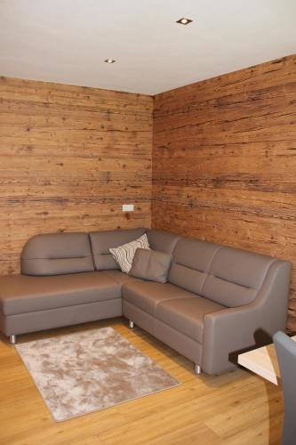 a living room with a couch and wooden walls at Appart Stefanie in Sankt Gallenkirch