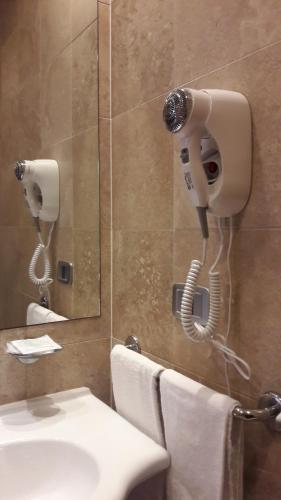 a bathroom with a shower with a phone on the wall at Residence Mediterraneo in Marina di Grosseto