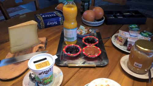 een tafel vol eten en een fles sap bij Guest House Chalet Saint Roch in Albiez-Montrond