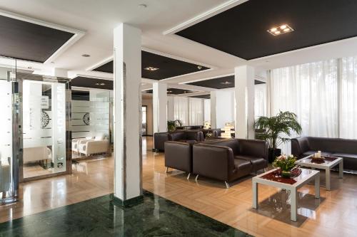 a lobby with leather chairs and tables in a building at Sandos Monaco - Adults Only in Benidorm