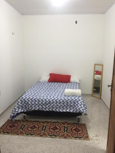 una camera da letto con un letto con un cuscino rosso e un tappeto di Pousada da Mamae a Barra Grande