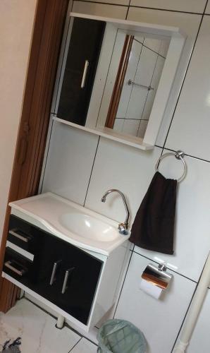 a bathroom with a sink and a mirror at Chalé Primavera - Eubiose in São Thomé das Letras