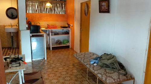 a room with a kitchen with a table and a refrigerator at Diani Hostel in Diani Beach