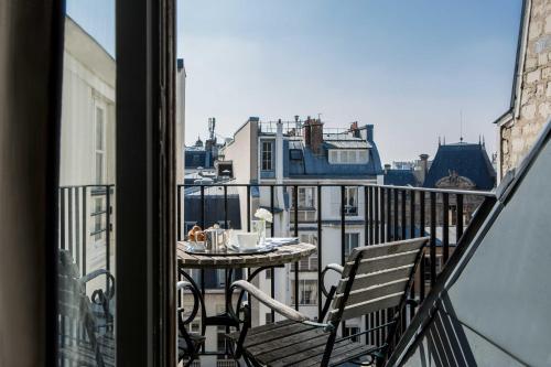 a balcony with a table and a view of a city at Hôtel d'Orsay - Esprit de France in Paris