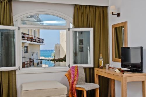 a living room filled with furniture and a tv at Xenia Hotel in Naxos Chora