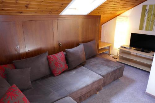 un sofá en una sala de estar con TV en Ferienwohnungen Schnarf en Valdaora