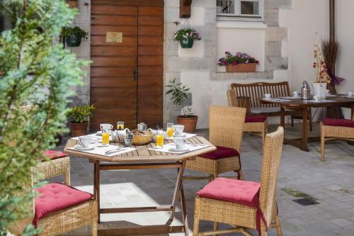 - une table et des chaises sur la terrasse dans l'établissement Appart Hotel Charles Sander, à Salins-les-Bains