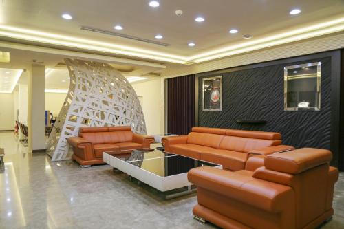 a lobby with two couches and a table and chairs at 德瑞旅店Direct Hotel in Kaohsiung