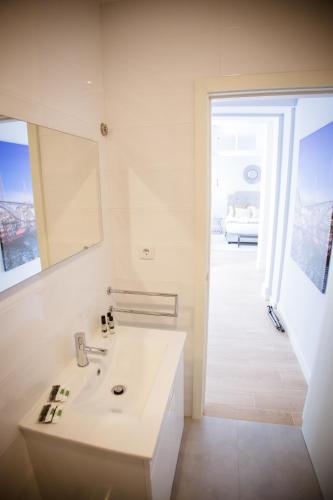 a white bathroom with a sink and a room at Porto Views & Wines by Porto City Hosts in Vila Nova de Gaia