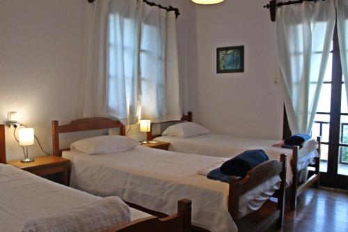 um quarto de hotel com duas camas e uma janela em Villa Magnolia em Chorefto