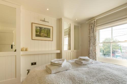a bedroom with two towels on a bed with a window at Nutshell in Aldeburgh