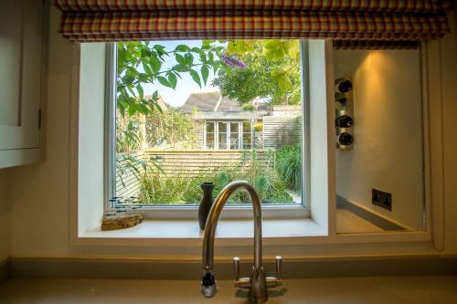 - un évier de cuisine avec une fenêtre au-dessus d'un évier dans l'établissement Nutshell, à Aldeburgh