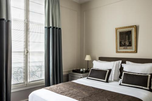 a bedroom with a large bed and a window at Hôtel Mansart - Esprit de France in Paris