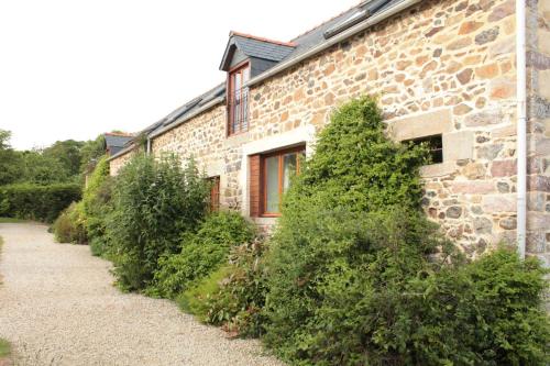 a stone building with bushes growing around it at Emerald Coast Gites and Lodge in Hénansal