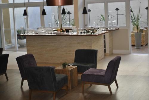 a bar with chairs and a table in a room at Hotel Amantykir in Itajubá