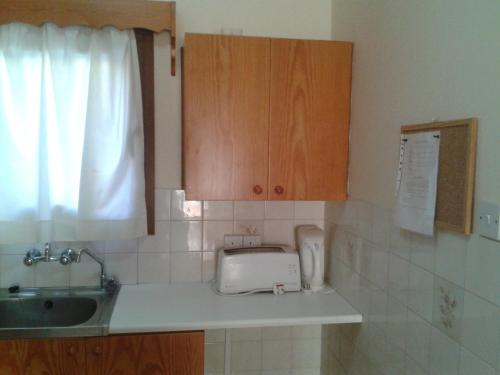 a kitchen with a sink and a toaster on a counter at Pelekanos Apartments in Pissouri