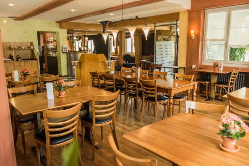 a restaurant with wooden tables and chairs at Hotel Restaurant Neuhaus in Nussbaumen