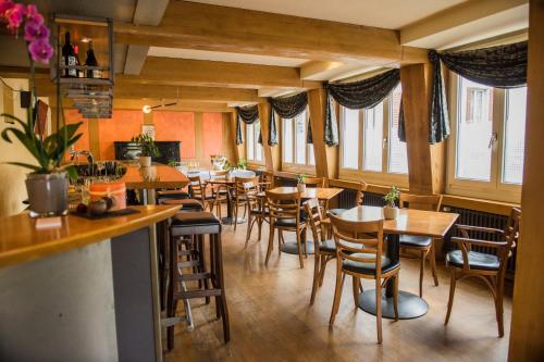 a restaurant with wooden tables and chairs and windows at Hotel Restaurant Neuhaus in Nussbaumen