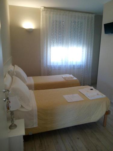 a bedroom with two beds and a window at La Terrazza sul Naviglio B&B in Bernate Ticino