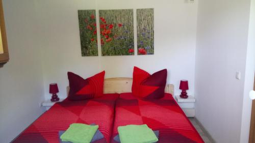 ヒンターヘルムスドルフにあるFerienwohnung Nimm dir Zeitの赤いベッド(赤い枕付)