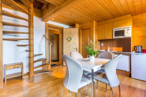 a kitchen and dining room with a table and chairs at Hotel Sterne in Beatenberg