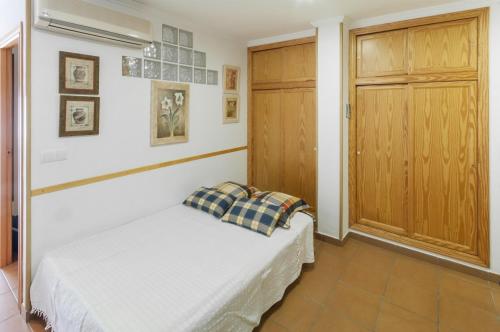 1 dormitorio con 1 cama y puerta de madera en Comtessa, en Oliva