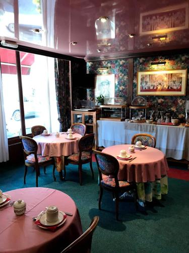 un restaurant avec deux tables et des chaises ainsi qu'une cuisine dans l'établissement Hotel La Diligence, à Honfleur