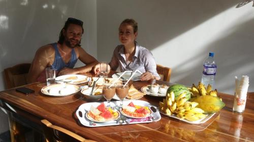 Un uomo e una donna seduti a un tavolo con del cibo di Rich Resort & Restaurant a Anuradhapura