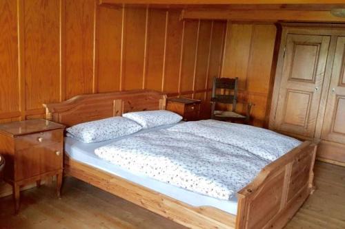 a wooden bed in a room with a wooden wall at Echtes Schwarzwaldhaus - Traditionell & Modern in Bernau im Schwarzwald