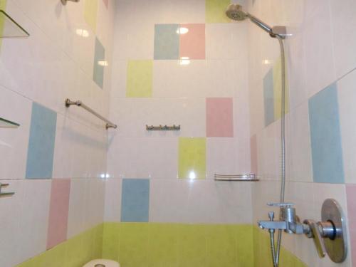 a bathroom with a shower with colorful tiles on the wall at Shuang Yang Sekinchan Homestay 6 in Sekincan
