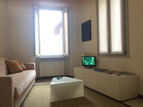 een woonkamer met een bank en een tv bij Appartamenti al Golfo in Salò