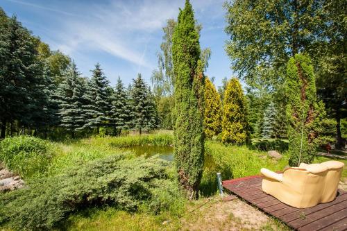 ウッチにあるGościniec u Zawierkiの庭園の木製デッキに座る黄色いソファ