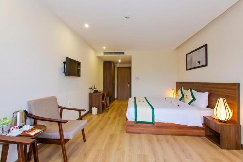 a bedroom with a bed and a desk and a chair at Ally Beach Boutique Hotel Hoian in Hoi An