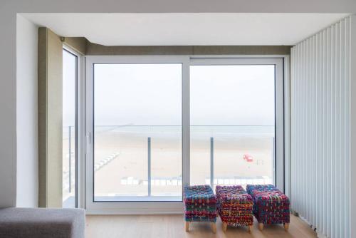 a room with a large window with a view of the beach at Sea View Apartment Knokke in Knokke-Heist