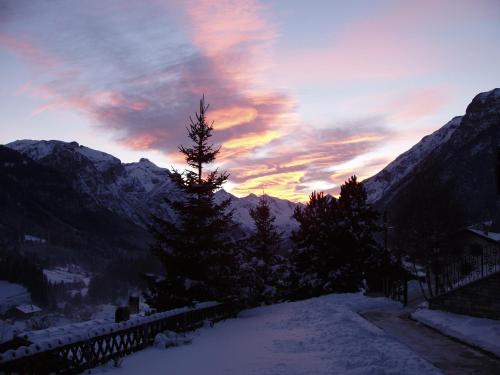 a sunset in the mountains with snow and trees at Haus Sonnleite in Trins