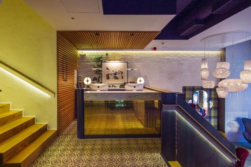 a lobby with a staircase and a couch and a table at Hotel Mirador de Chamartín in Madrid
