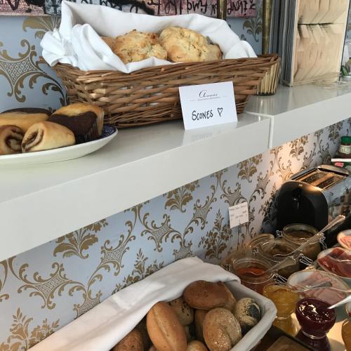 a shelf with a basket of bread and pastries at Annas Hotell in Kristianstad
