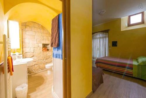 a room with a bathroom with a sink and a bed at Maisonrua' in Ascoli Piceno