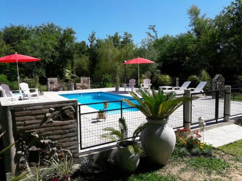 a pool with chairs and umbrellas in a yard at Guidai Bilu in San José