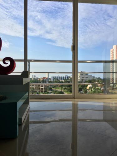 a room with a large window with a view of a city at Playa y alberca en Zona Marina in Mazatlán
