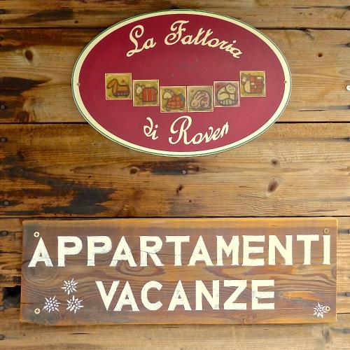 a sign for a restaurant on a wooden wall at La Fattoria di Roven in Gignod