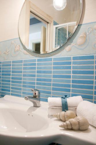 a bathroom with a sink and a mirror and towels at Villa Mazzanta Relais & Hotel in Vada