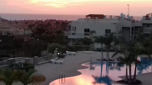 Vistas al mar de una piscina con un edificio en Apartamento Sunset, en Palm-mar