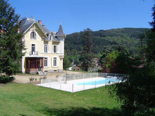 une grande maison avec une piscine devant dans l'établissement Les Chalets du Domaine des Soyeux, à Saint-Julien-Molin-Molette